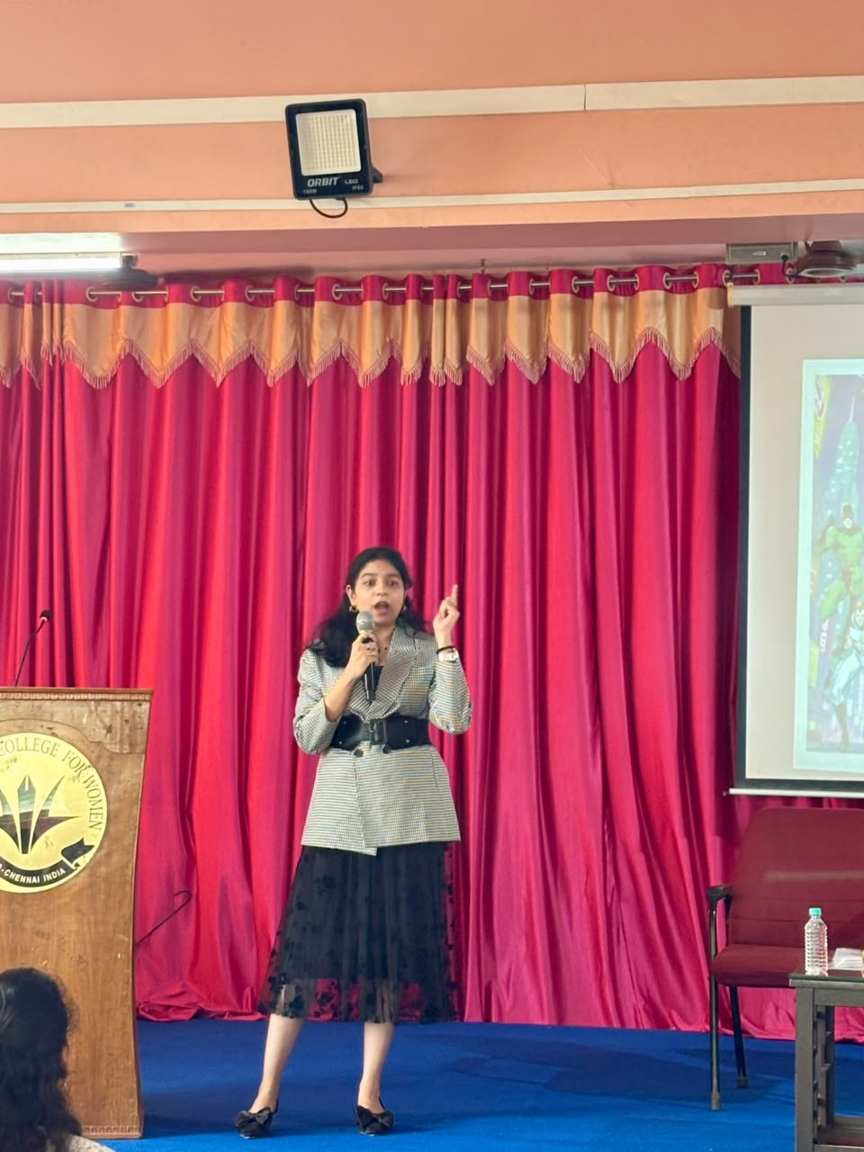 Naveena Srinivasan speaking to students in an auditorium